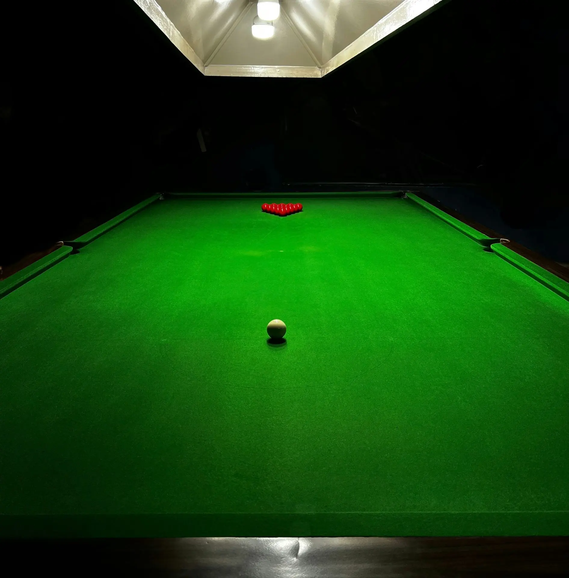 A snooker table with balls and rack